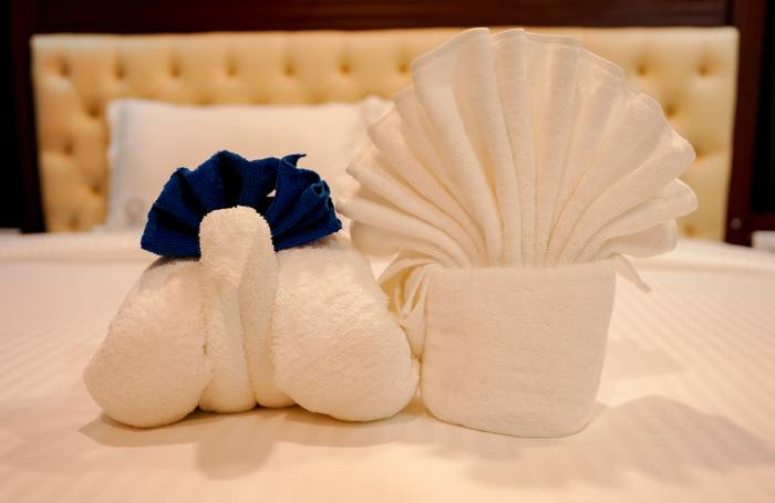 Turndown towel art on a bed at Legacy Square Hotel